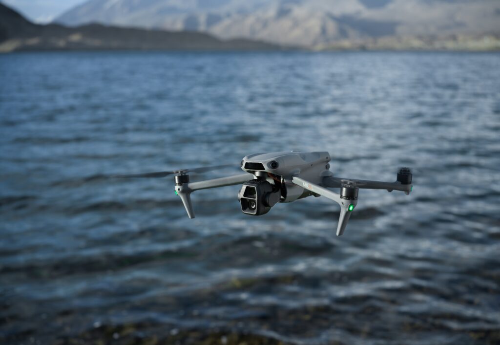Foto do drone DJI Air 3s voando sobre o mar.
English: a drone flying over water