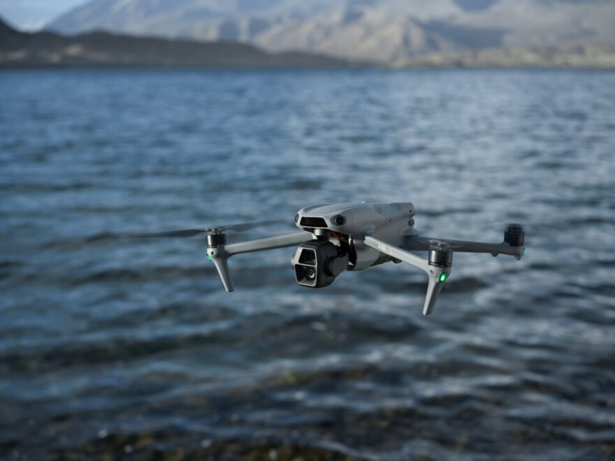 Foto do drone DJI Air 3s voando sobre o mar. English: a drone flying over water